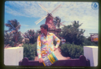 Man poseert met Aruba Visitors Guide voor Restaurant "The Mill", de Olde Molen". Origineel opschrift: "Manchester", Aruba Tourism Bureau