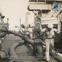 Unloading vegetables from Venezuela, while the crude is being pumped out of the holds of the lake tankers (#12001, Lago , Aruba, April-May 1944), Morris, Nelson