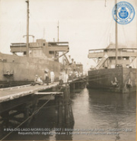 Unloading vegetables from Venezuela, while the crude is being pumped out of the holds of the lake tankers (#12007, Lago , Aruba, April-May 1944), Morris, Nelson