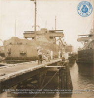 Unloading vegetables from Venezuela, while the crude is being pumped out of the holds of the lake tankers (#12008, Lago , Aruba, April-May 1944), Morris, Nelson