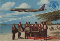 Greetings from Aruba (Postcard, ca. 1969) Trans Caribbean jet plane arriving in Aruba, Netherlands Antilles. Steel Band playing on the beach, Palm Beach, Aruba