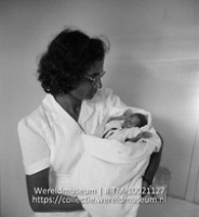 Een vroedvrouw met een baby op haar arm; Vroedvrouw, werkzaam op Saba, met zes-maands kindje (Collectie Wereldmuseum, TM-10021127)