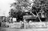 Guesthouse te Oranjestad, St. Eustatius (singles en gele waalsteentjes); Een ommuurde woning gelegen aan zee met naast de ingang een vlaggenmast (Collectie Wereldmuseum, TM-10021236)