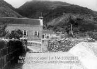Saba. The Bottom; Een straatgezicht met aan het einde een kerk, gelegen tegen een berghelling (Collectie Wereldmuseum, TM-10021373)