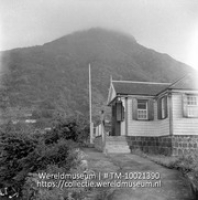 Guesthouse te Windwardside. Saba.; Een gastenverblijf op het bergachtige Saba met op de achtergrond een berg in de mist (Collectie Wereldmuseum, TM-10021390)