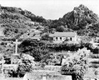 Kerkhof en gezicht op Windwardside, Saba; Zicht over een kerkhof gelegen aan de voet van een berg (Collectie Wereldmuseum, TM-10021395)