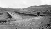 Bijna voltooide dam op Barber, Curacao. Op de voorgrond de overlaat; de insnijding is bovenstrooms; Een bijna voltooide dam bij Barber (Collectie Wereldmuseum, TM-10021690)
