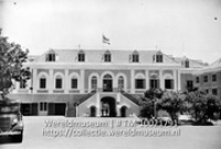 Curacao. Paleis van den Gouverneur vanaf Binneplein Waterfort; Het paleis van de gouverneur met op het dak een gehezen Nederlandse vlag (Collectie Wereldmuseum, TM-10021791)