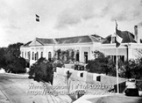 West-Indie. Curacao. Gouvernementsgebouw; Het gouvernementshuis op Curacao met gehezen Nederlandse vlaggen hoog in de mast (Collectie Wereldmuseum, TM-10021793)