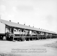 Type eerste arbeiderswoningen, waar voornamelijk Venezolanen wonen, Isla, Willemstad, Curacao; Lange rij arbeiderswoningen met een verhoogde entree en eigen opgang (Collectie Wereldmuseum, TM-10021819)