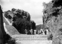Curacao. Thermopile bij Beekenburg; Een groep antillianen in werkkleding poseert tussen rotsen en voor een trap (Collectie Wereldmuseum, TM-10021856)