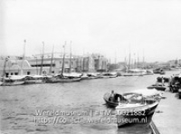 Curacao. Ingang van het Waaigat; Havengezicht van Willemstad met aangemeerde schepen (Collectie Wereldmuseum, TM-10021882)