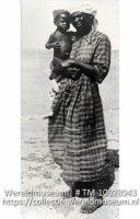 Bonaire. Vrouw met kind (negertype); Een vrouw met een kind op haar arm op het strand van Bonaire; A woman with a child on her arm on the beach of Bonaire (Collectie Wereldmuseum, TM-10028943)