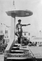 Verkeersagent. Curacao; Een verkeersagent op een verhoogd podium op Curacao; A constable on point duty in Curacao (Collectie Wereldmuseum, TM-10028976)