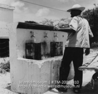 Man vult tanks bij de waterput van plantage Aruba; De waterput. Plantage Aruba (Collectie Wereldmuseum, TM-20003810), Lawson, Boy