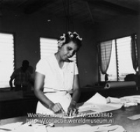 Vrouw met krulspelden in het haar in een atelier van de Cambes confectiefabriek; Textielfabriek. Atelier (Collectie Wereldmuseum, TM-20003842), Lawson, Boy