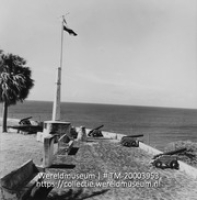 Fort Oranje met vlaggemast, herdenkingssteen en kanonnen gericht op zee; Fort Oranje en monument met gedenksteen aangeboden door wijlen Pres. Roosevelt, ter ere van het eerste saluut aan de vlag der U.S.A. (Collectie Wereldmuseum, TM-20003953), Lawson, Boy