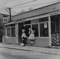 Central store, Philipsburg.; Twee vrouwen met kinderen bij de Central Store; Two women with children at the Central Store (Collectie Wereldmuseum, TM-20006284), Lawson, Boy