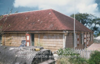 Woning, op de voorgrond een regenbak; Woning met regenbak op de voorgrond, het huis van de plaatselijke kapper. (Collectie Wereldmuseum, TM-20029484), Lawson, Boy