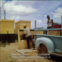 Mannen halen water bij een waterput waarbij het water wordt opgepompt door middel van windkracht; Boeren halen water uit een punt, waar het water opgepompt wordt met windkracht (Collectie Wereldmuseum, TM-20029696), Lawson, Boy