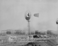 Curacao; Windmolens bij een groot afgezet terrein met raffinaderijen (Collectie Wereldmuseum, TM-60047581)