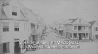Kijkje in een straat in Willemstad of Paramaribo, waarin veel transport van handelswaar plaatsvindt (Collectie Wereldmuseum, TM-60048022)