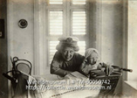 Baby Wilhelm de Gaay Fortman in de kinderwagen met daarachter zijn moeder met een marine pet op (Collectie Wereldmuseum, TM-60050742)