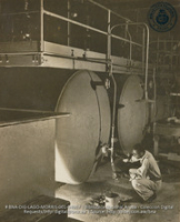 Man, wearing safety equipment, testing sulphuric acid being manufactured at Acid Contact Plant (#4967, Lago , Aruba, April-May 1944), Morris, Nelson