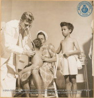 Dr. J.B.M. Van Ogtrop examining Aruban children during daily clinic (#5041, Lago , Aruba, April-May 1944), Morris, Nelson