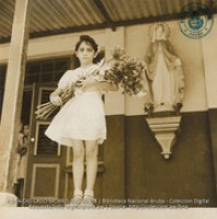 Young Aruban Catholic child with floral tribute to Sisters in Parochial School, Catholic Church, Santa Cruz (#5358, Lago , Aruba, April-May 1944)
