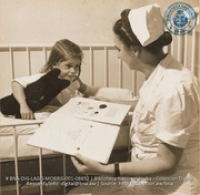 Story-telling hour; nurse and little girl patient in foreign staff wing of Lago Hospital (#8852, Lago , Aruba, April-May 1944), Morris, Nelson