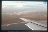 Luchtfoto Curaçao met midden in beeld de Isla-raffinaderij, gezien vanuit raam van passagiersvliegtuig, Vredebregt, Casper