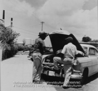 Twee mannen in gesprek bij een auto met openstaande motorkap (Collectie Wereldculturen, TM-20003673), Lawson, Boy (1925-1992)