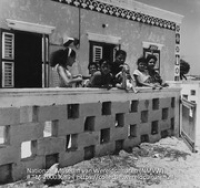 Groepsfoto van de bewoners van een woning bij de erfafscheiding van steen (Collectie Wereldculturen, TM-20003689), Lawson, Boy (1925-1992)