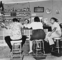 Interieur van een bar, de bezoekers aan de bar op de rug gezien (Collectie Wereldculturen, TM-20003703), Lawson, Boy (1925-1992)