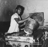 Werknemer in de kaarssenfabriek van de Aruba Candle Company (Collectie Wereldculturen, TM-20003728), Lawson, Boy (1925-1992)