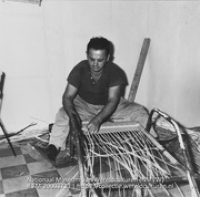 Een rietvlechter vernieuwd de zitting van een stoel (Collectie Wereldculturen, TM-20003733), Lawson, Boy (1925-1992)